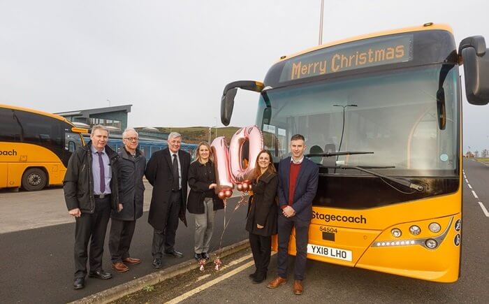Fife Council and Stagecoach representatives stand in front of a bus. The park and ride facility is in the background.