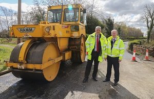 Steam roller on road with Cllr. Altany Craik & Alistair Donald, Roads & Transportation Services and John