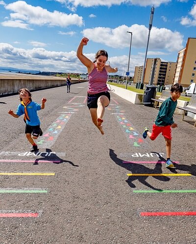 Woman and two boys jumping