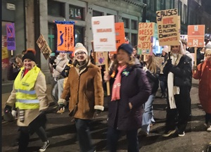 Group of women walking at night with placards