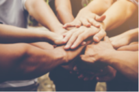 A group of eight hands all in the middle of a circle, in a show of solidarity