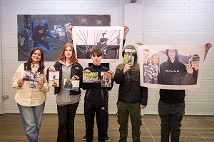 Group of people holding up photographs