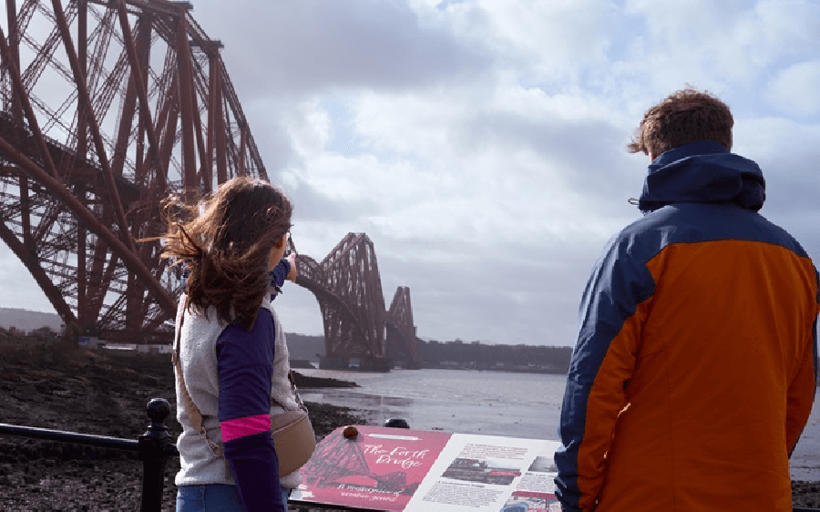Two people looking at the Forth Rail Bridge